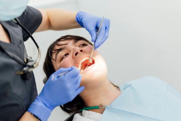 Dentist examining teeth of patient with angled mirror in clinic model released, Symbolfoto property released, PGF01736