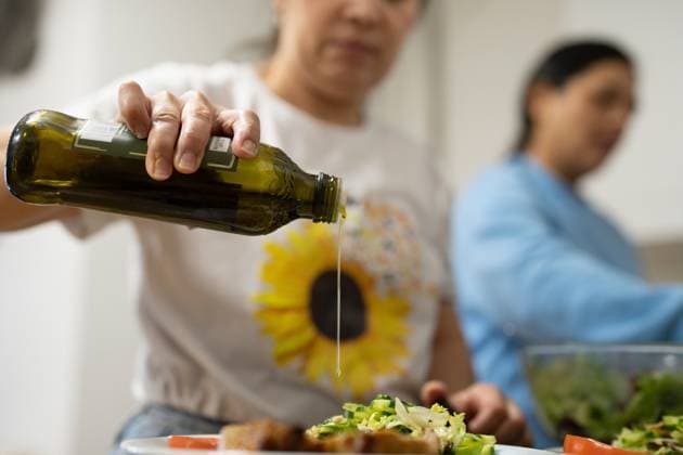 Woman using olive oil for meal, close up model released Copyright: xCulturaxCreativex