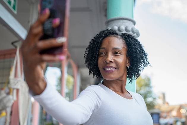 Smiling woman taking selfie in front of building model released Copyright: xCulturaxCreativex