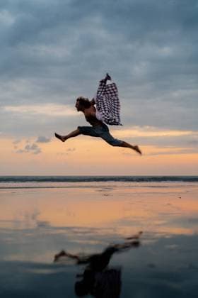 Creative Highlights Symbolbilder Happy man jumping into the sky on a beach ocean, reflection. Kuta Utara, Bali, Indonesia CR_YUKI240619E7-1462639-01 ,model released, Symbolfoto