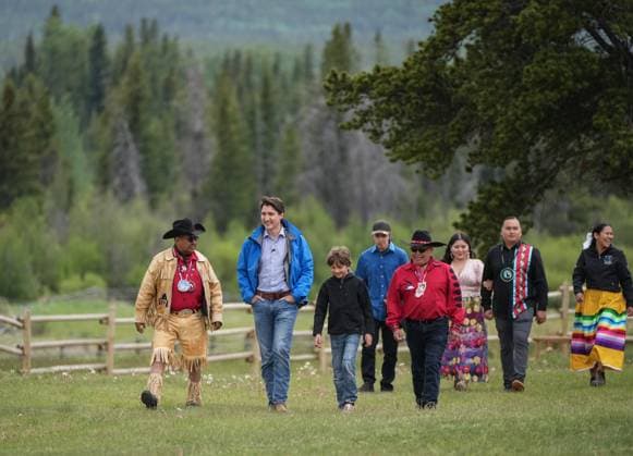 June 26, 2024, Nemaiah Valley, Bc, CANADA: Prime Minister Justin Trudeau, second left, and his son Hadrien, 10, walk with Chief Roger William, left, and Chief Otis Guichon, front right, as they arrive for community celebrations to mark the 10th anniversary of the Tsilhqot in decision, in Nemaiah Valley, B.C., on Wednesday, June 26, 2024. In 2014, the Supreme Court of Canada granted Tsilhqot in aboriginal title to more than 1,750 square kilometres of land in the Nemiah Valley. Nemaiah Valley CANADA - ZUMAc35_ 20240626_zaf_c35_148 Copyright: xDarrylxDyckx