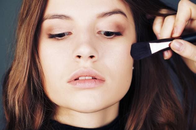 Close-up portrait . In the face of the girl model, make-up artist on the basis of tone is a special brush. Face Care , bb and cc cream. Nude make up ,model released, Symbolfoto