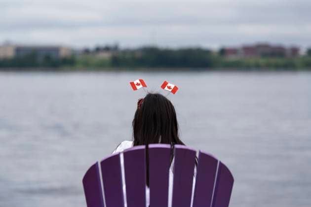 July 1, 2024, Halifax, Ns, Canada: A reveller wearing a Canada flag fascinator sits in an Adirondack chair on the waterfront on Canada Day in Halifax on Monday, July 1, 2024. Due to inclement weather, a number of Canada Day celebrations were cancelled in Halifax. Halifax Canada  - ZUMAc35_ 20240701_zaf_c35_078 Copyright: xDarrenxCalabresex