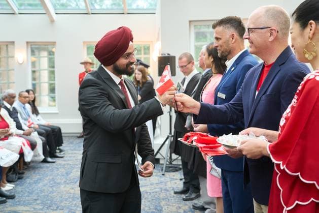 July 1, 2024, Winnipeg, Mb, Canada: New Canadian citizen Gurpreet Singh, originally from India, is handed a Canadian flag by Winnipeg Mayor Scott Gillingham during a Canada Day citizenship ceremony at the Assiniboine Park Pavilion in Winnipeg, Monday July 1, 2024. Winnipeg Canada  - ZUMAc35_ 20240701_zaf_c35_047 Copyright: xDavidxLipnowskix