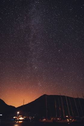 Amazing Beauty of a Night Scene on a Harbor of Sailboats. Gorgeous Starry Sky over High Mountains. Luxury Summer Vacation.. Night Scene on a Harbor ,model released, Symbolfoto