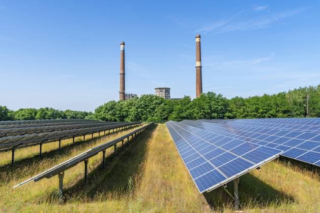 Solar modules of a solar park in front of the decommissioned Plessa lignite-fired power plant with two chimneys and cooling towers, Plessa, Lusatia, Brandenburg, Germany, Europe *** Solar Modules of a Solar Park in Front of The decommissioned Plessa lignite FIRED Power plant With Two Chimneys and Cooling towers, Plessa, Lusatia, Brandenburg, Germany, Europe Copyright: imageBROKER OliverxGerhard ibxoge10916426.jpg