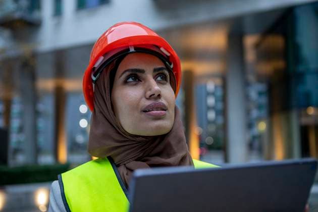 UK, London, Female engineer in hijab and hardhat using digital tablet model released Copyright: xCulturaxCreativex