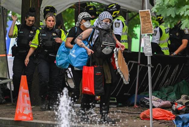 July 5, 2024, Montreal, Pq, Canada: Police escort pro-Palestine supporters away from a protest encampment in Victoria Square in Montreal, Friday, July 5, 2024, following a police intervention earlier in the morning. Montreal Canada  - ZUMAc35_ 20240705_zaf_c35_027 Copyright: xGrahamxHughesx