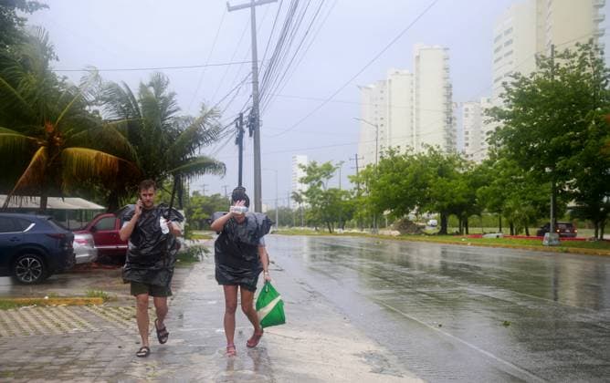 (240705) -- CANCUN (MEXICO), July 5, 2024 -- People walk in the rain after the landfall of Hurricane Beryl, in Cancun, Quintana Roo state, Mexico, on July 5, 2024. Over 1 million people in the Caribbean have been affected by Hurricane Beryl, UN humanitarians said Friday. As a category 4 hurricane that has claimed at least 11 lives so far, Beryl left a trail of destruction in Grenada and Saint Vincent and the Grenadines on Monday, then impacting Jamaica on Wednesday. The hurricane is currently affecting Belize and Mexico. (Photo by Xinhua) MEXICO-CANCUN-HURRICANE BERYL AlbertoxValdez