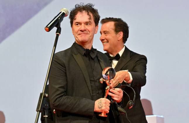 The British documentary Sudden Glimpse of Deeper Things by Mark Cousins (left) won the Grand Prix (Crystal Globe) in the main competition of the Karlovy Vary Film Festival today at the closing awards ceremony of the 58th Karlovy Vary International Film Festival, in Karlovy Vary, Czech Republic, on July 6, 2024. On the right is British actor Clive Owen. (CTKxPhoto OndrejxHajek) CTKPhotoP2024070605302  CTKPhotoP2024070605302