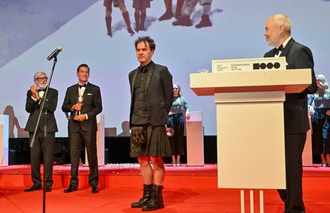 The British documentary Sudden Glimpse of Deeper Things by Mark Cousins (centre) won the Grand Prix (Crystal Globe) in the main competition of the Karlovy Vary Film Festival today at the closing awards ceremony of the 58th Karlovy Vary International Film Festival, in Karlovy Vary, Czech Republic, on July 6, 2024. From left: festival president Jiri Bartoska and British actor Clive Owen and right moderator Marek Eben. (CTKxPhoto OndrejxHajek) CTKPhotoP2024070605313  CTKPhotoP2024070605313