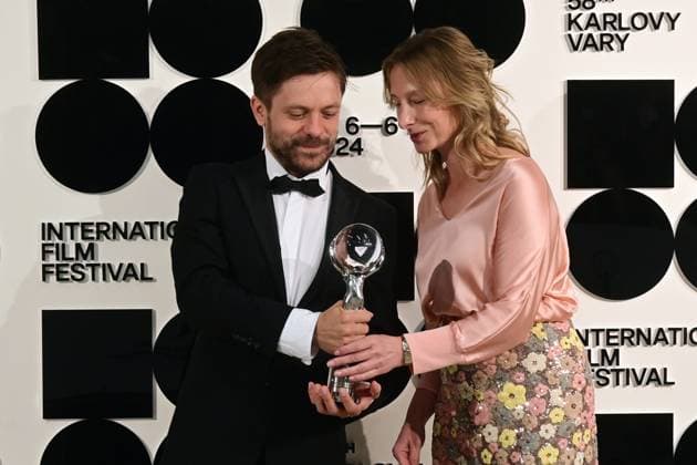 Director and actor Jiri Madl, left, and producer Monika Kristlova pose in front the photo wall with their Pravo Audience Award for the film Waves after the closing awards ceremony of the 58th Karlovy Vary International Film Festival, in Karlovy Vary, Czech Republic, on July 6, 2024. (CTKxPhoto SlavomirxKubes) CTKPhotoP2024070605421  CTKPhotoP2024070605421
