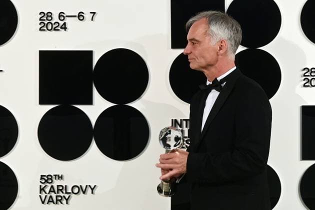 Actor Ivan Trojan poses in front the photo wall with his President s Award of Karlovy Vary International Film Festival for outstanding contribution to Czech cinema after the closing awards ceremony of the 58th Karlovy Vary International Film Festival, in Karlovy Vary, Czech Republic, on July 6, 2024. (CTKxPhoto SlavomirxKubes) CTKPhotoP2024070605446  CTKPhotoP2024070605446