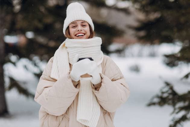 Happy smiling young woman portrait dressed coat scarf hat and mittens enjoys winter weather at snowy winter park. Happy smiling young woman with coffee hot drink cup enjoys winter weather at snowy winter park ,model released, Symbolfoto Copyright: xZoonar.com MaksimxChernyshevx 21810879 ,model released, Symbolfoto ,property released