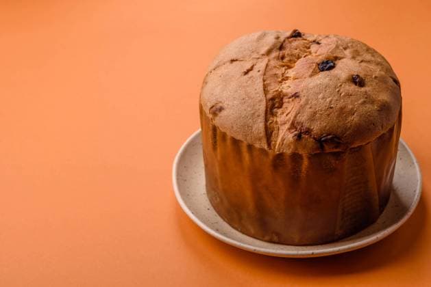 Delicious sweet holiday panettone cake with zest and raisins on a ceramic plate Delicious sweet holiday panettone cake with zest and raisins on a ceramic plate. Holiday table attribute Copyright: xZoonar.com TetianaxChernykovax 21824751