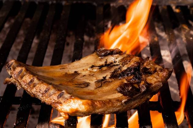 A succulent pork chop is expertly grilled over a fiery barbecue, capturing the essence of traditional Mexican home cooking. The flames lick the meat, enhancing its flavors. Model Released EduardoGavira_ID22276_651178_004 Copyright: xEduardoxGavirax