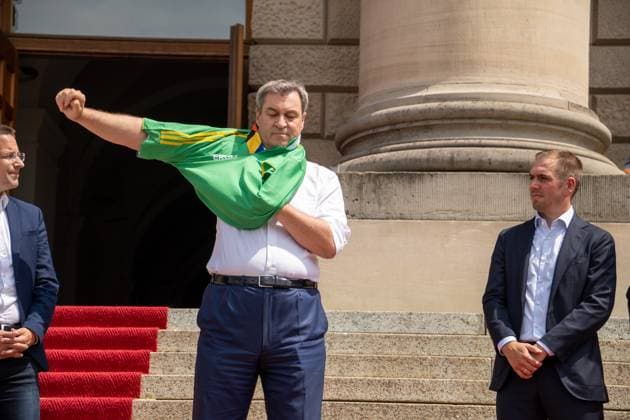 Munich, Bavaria, Germany - 11 July 2024: Prime Minister of Bavaria Dr. Markus Söder honoring the volunteers of the European Championship. He puts on a Volunteers jersey and stands next to tournament goalkeeper Philipp Lahm