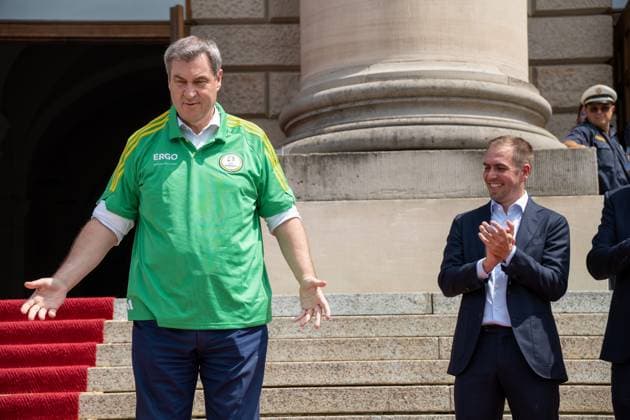 Munich, Bavaria, Germany - 11 July 2024: Prime Minister of Bavaria Dr. Markus Söder honoring the volunteers of the European Championship. He puts on a Volunteers jersey and stands next to tournament goalkeeper Philipp Lahm
