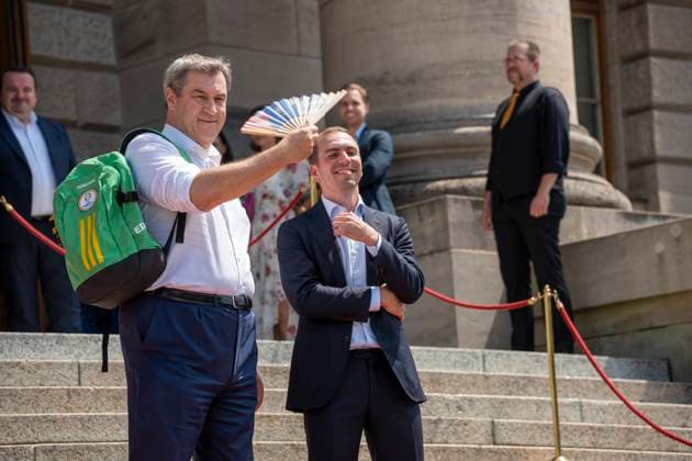 Munich, Bavaria, Germany: 11 July 2024: Dr. Markus Söder, Minister President of Bavaria, waves a UEFA fan because he is very hot. At the award ceremony for the volunteers of the UEFA Euro 2024 European Championship in Germany in Munich in the lower Hofgarten.