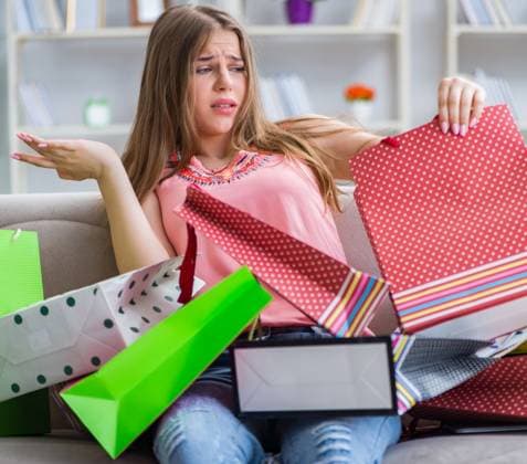 The young woman with shopping bags indoors home on sofa. Young woman with shopping bags indoors home on sofa ,model released, Symbolfoto