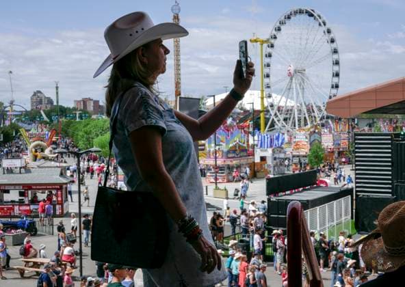 July 14, 2024, Calgary, Ab, CANADA: A visitor records the view during the final day of the Calgary Stampede in Calgary, Sunday, July 14, 2024. Calgary CANADA  - ZUMAc35_ 20240714_zaf_c35_015 Copyright: xJeffxMcintoshx