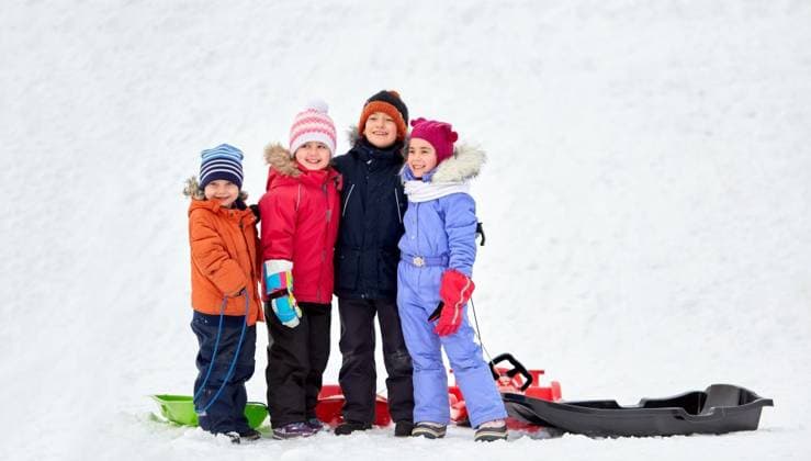 childhood, friendship and season concept - group of happy little kids with sleds hugging in winter. happy little kids with sleds hugging in winter ,model released, Symbolfoto