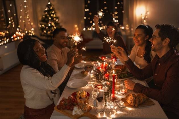 holidays and celebration concept - multiethnic group of happy friends with sparklers having christmas dinner at home. happy friends with sparklers at christmas dinner ,model released, Symbolfoto