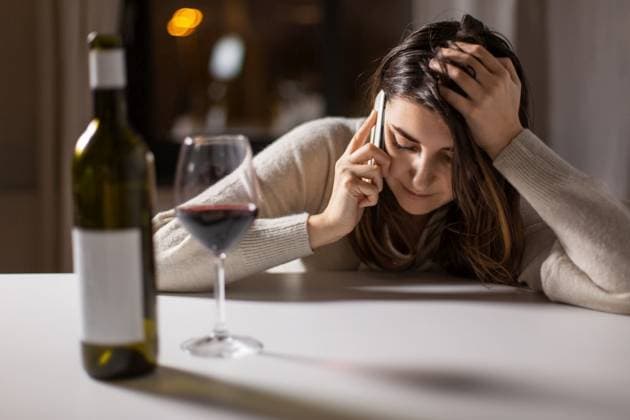 alcoholism, alcohol addiction and people concept - angry drunk woman or female alcoholic drinking red wine and calling on smartphone at home. woman alcoholic drinking wine and calling on phone ,model released, Symbolfoto