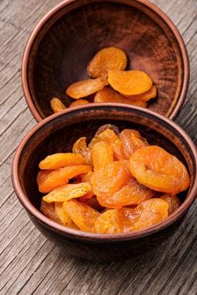 Delicious dried apricots in a bowl.Dried apricots on old wooden table. Heap of dried apricots ,model released, Symbolfoto