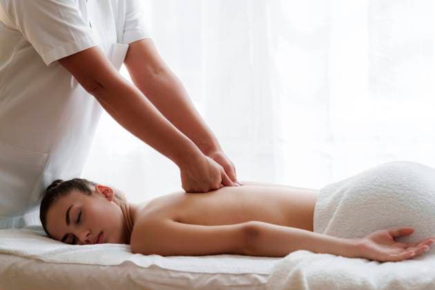 Osteopath massaging back of teenage girl lying on front in health spa model released, Symbolfoto, AAZF01991