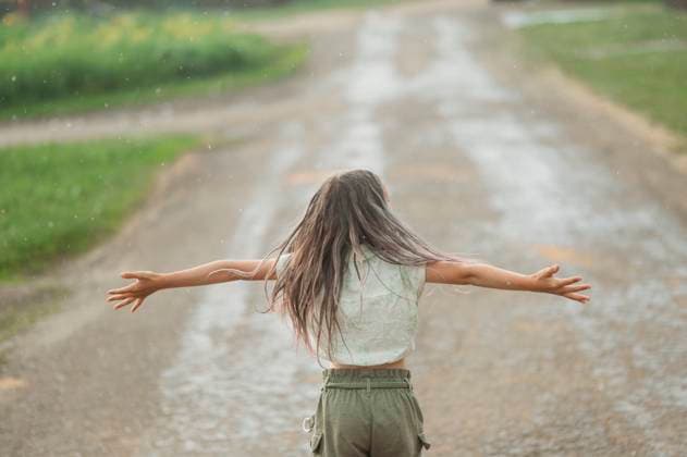 Long hair girl with arms outstretched standing and enjoying rain at back yard model released, Symbolfoto, ANAF03336