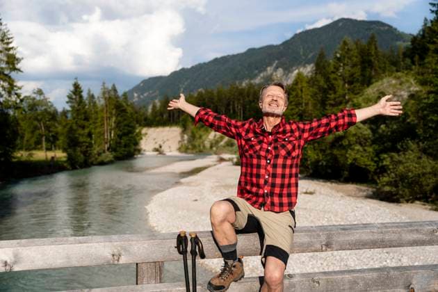 Cheerful man enjoying a hike in the mountains on a sunny day near a river in Germany. model released, Symbolfoto, DIGF21470