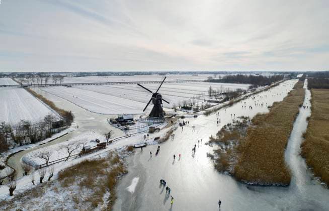 Drone view of tourists ice skating on frozen lake in Netherlands, Lexmond Utrecht Nederland Achthoven MKJF00872