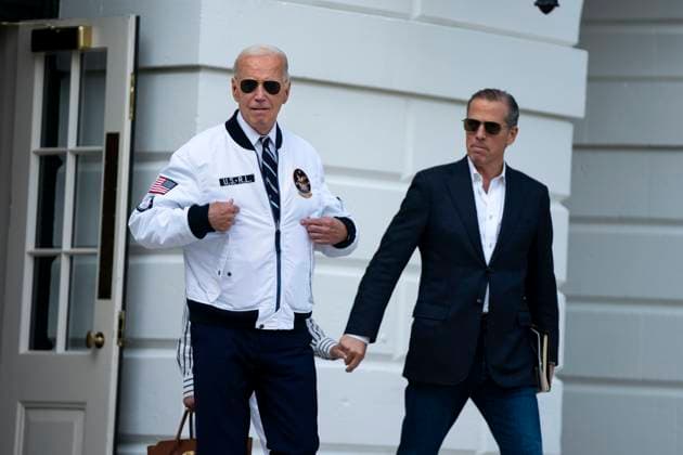United States President Joe Biden gestures to his Team USA jacket as Hunter Biden looks on while exiting the White House to board Marine One en route to Camp David in Washington, DC on Friday, July 26, 2024. The 2024 Paris Olympics will take place from July 26 to August 11. Copyright: xCNPx xMediaPunchx
