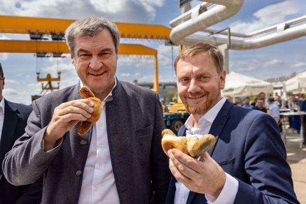 Der sächsische Ministerpräsident Michael Kretschmer (CDU,r.) und der bayrische Ministerpräsident Markus Söder (CSU,l.) halten eine Bratwurst nach einem Arbeitstreffen in der Firma Plauen Stahl in Plauen am 25.07.2024. Am 01. September wird in Sachsen ein neuer Landtag gewählt. Plauen Sachsen Deutschland *** The Saxon Prime Minister Michael Kretschmer CDU,r and the Bavarian Prime Minister Markus Söder CSU,l hold a bratwurst after a working meeting at the Plauen Stahl company in Plauen on July 25, 2024 On September 01, a new state parliament will be elected in Saxony Plauen Saxony Germany