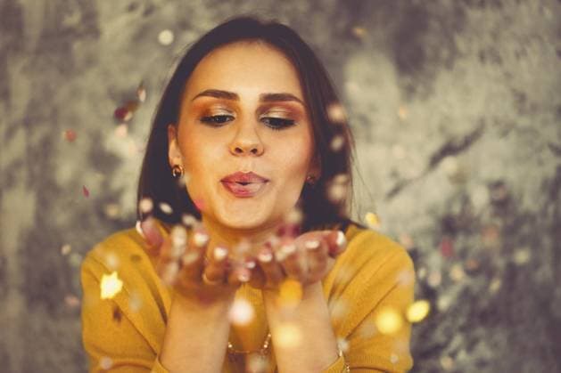 Creative Highlights Symbolbilder Happy beautiful brunette girl wearing yellow sweater blowing on confetti isolated on vintage background with lights Copyright: imageBROKER DashaxPetrenko ibxiqx10537339.jpg ,model released, Symbolfoto ,property released