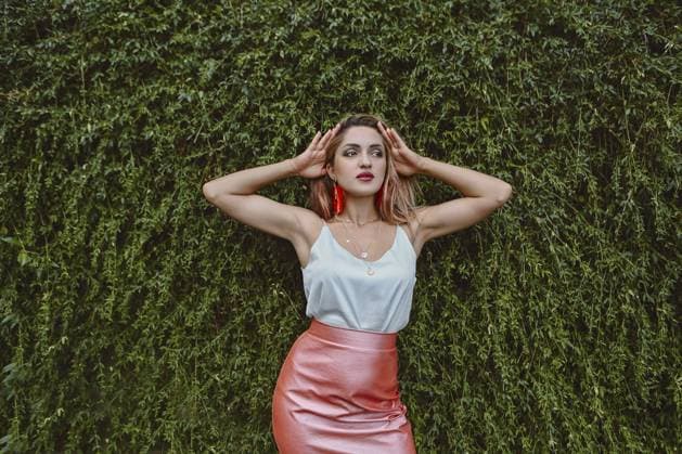 Creative Highlights Symbolbilder Beautiful young fashionable woman in pink skirt and blue top standing among green leaves Copyright: imageBROKER DashaxPetrenko ibxiqx10540197.jpg ,model released, Symbolfoto ,property released