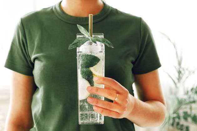 Creative Highlights Symbolbilder Young woman holding fresh lime, lemon and mint infused water, cocktail, detox drink, lemonade in reusable bottles Copyright: imageBROKER DashaxPetrenko ibxiqx10540659.jpg ,model released, Symbolfoto ,property released