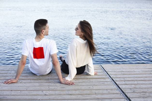 Creative Highlights Symbolbilder Back view of young happy girlfriend and boyfriend sitting on wooden quay and looking at each other while enjoying weekend near lake Copyright: imageBROKER DashaxPetrenko ibxiqx10541269.jpg ,model released, Symbolfoto ,property released