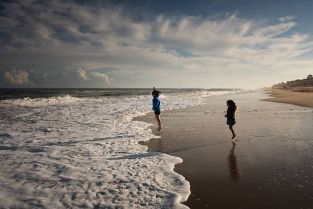 Young sisters jumping in ocean waves Outer Banks Nags Head, North Carolina, United States R_JOKU240729-1472187-01 ,model released, Symbolfoto