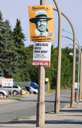 Wahlplakate 31.07.2024, Weimar, Wahlplakate zur Landtagswahl am 01.09.2024 in Thueringen im Bild: Wahlplakat der Werteunion - Clarsen Ratz Der Mann mit dem Mut, darunter ein Plakat der MLPD - Arm und Reich wird es immer geben - sagen die Superreichen *** Election posters 31 07 2024, Weimar, election posters for the state election on 01 09 2024 in Thuringia in the picture election poster of the Werteunion Clarsen Ratz The man with the courage, below a poster of the MLPD Poor and rich will always exist say the super rich