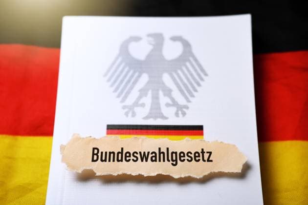FOTOMONTAGE, Zettel mit Aufschrift Bundeswahlgesetz auf Gesetzbuch *** PHOTOMONTAGE, note with inscription Federal Election Act on law book ** NUR FUER REDAKTIONELLE ZWECKE ** EDITORIAL USE ONLY **