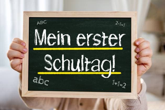 2 August 2024: My first day at school! Return to school after the vacations Concept. A child holds a chalkboard with the words: My first day at school! PHOTOMONTAGE *** Mein erster Schultag! Rückkehr zur Schule nach den Ferien Konzept. Ein Kind hält eine Kreidetafel mit Aufschrift: Mein erster Schultag! FOTOMONTAGE