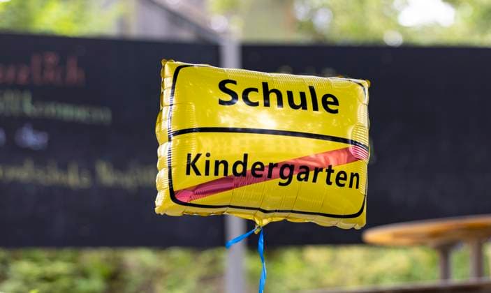 03.08.2024, Deutschland, auf dem Foto ein gelbes Luftkissen mit der Beschriftung Schule sowie Kindergarten (rot durchgestrichen), symbolisch für den Abschied von Kindern aus dem Kindergarten und dem Eintritt in das Schulleben *** 03 08 2024, Germany, on the photo a yellow air cushion with the inscription school and kindergarten crossed out in red, symbolizing the departure of children from kindergarten and entry into school life
