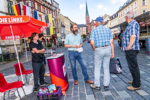 Die Linke, Wahlkampf in Thüringen, Wahlkampfstand auf dem Marktplatz in Altenburg, 3. August 2024 Deutschland, Altenburg, 3. August 2024, Ralf Plötner, MdL, Abgeordneter Die Linke im thüringischen Landtag, bei Wahlkampf in Altenburg, Wahlkampfstand am Samstagmorgen auf dem Marktplatz Altenburg, Plötner sucht das Gespräch mit Bürgern, verteilt Wahlkampfmaterial, die Landtagswahlen sind am 1. September, Parteien, Politiker, Politik, *** Die Linke, election campaign in Thuringia, election campaign stand on the market square in Altenburg, 3 August 2024 Germany, Altenburg, 3 August 2024, Ralf Plötner, MdL, Member of Parliament for Die Linke in the Thuringian state parliament, at election campaign in Altenburg, election campaign stand on Sa