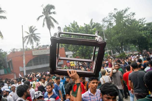 Dhaka celebrate the resignation of the Prime Minister - 05 Aug 2024 A man goes out with a chair from Ganobhaban (the official residence of the Prime Minister of Bangladesh). Thousands of People celebrate the resignation of Bangladeshi Prime Minister Sheikh Hasina. Protests in Bangladesh that began as student-led demonstrations against government hiring rules in July culminated on August 5, in the Prime Minister fleeing and the military announcing it would form an interim government. Dhaka Bangladesh Copyright: xPiyasxBiswasx xSOPAxImagesx BangladeshCelebration (9)