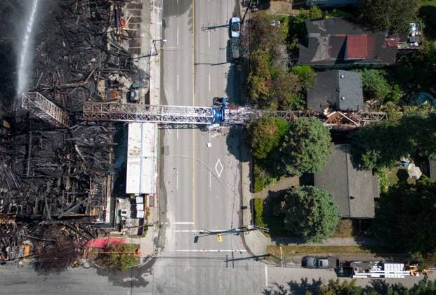August 7, 2024, Vancouver, Bc, CANADA: A crane that collapsed during a fire at an apartment building under construction on Tuesday lies across the road, as firefighters direct water on the remains of the structure in Vancouver, on Wednesday, August 7, 2024. The fire destroyed the building under construction and damaged nine other nearby homes. Vancouver CANADA  - ZUMAc35_ 20240807_zaf_c35_155 Copyright: xDarrylxDyckx