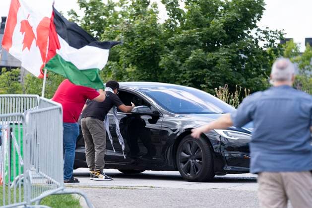 August 10, 2024, Brampton, On, Canada: Pro Palestinian protesters, left, yell at drivers attending a Liberal Party Fundraising event in anticipation of the arrival of Prime Minister Justin Trudeau (not pictured), as a police officer directs traffic, right, in Brampton, Ont., Saturday, August 10, 2024. Brampton Canada - ZUMAc35_ 20240810_zaf_c35_172 Copyright: xArlynxMcadoreyx