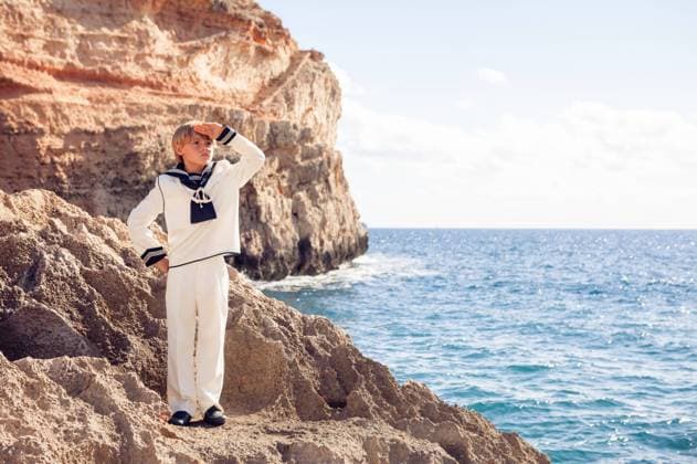 Creative Highlights Symbolbilder Preteen boy in marine outfit standing at stony seaside A young boy in a sailor suit stands by the sea on a rocky coast, shading his eyes as if looking into distance, possibly celebrating his First Communion. Model Released PHE44B~1 Copyright: xx RECORD DATE NOT STATED