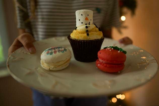 Snowman cupcake and holiday macarons on white plate Wooster, Ohio, United States R_JOKU240807-1508756-01